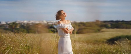 Beautiful Asian young woman in white dress outdoor in flower field. embracing fresh air and engaging in outdoor activities. Friluftsliv concept means spending as much time outdoors as possible