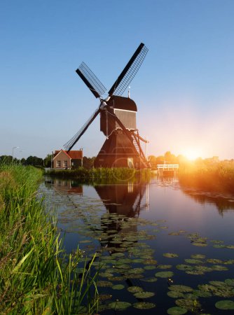 Foto de Molino de viento cerca del agua a la luz del sol en Holanda. - Imagen libre de derechos