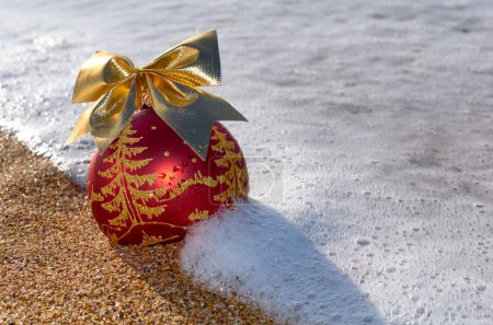 Foto de Decoración del árbol de Navidad en la arena de la playa en la espuma de la ola del mar - Imagen libre de derechos