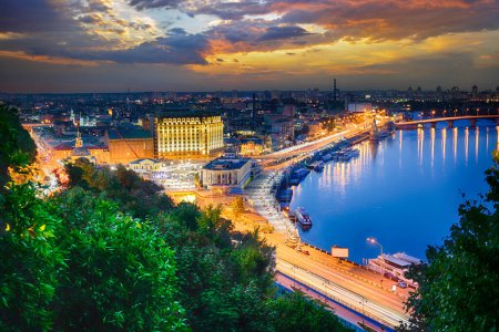 Téléchargez les photos : Picturesque evening landscape of the Postal Square, the river station and the Dnieper River in the capital of Ukraine, the city of Kyiv. Skyline of Podil and Obolon at night in Kiev. - en image libre de droit