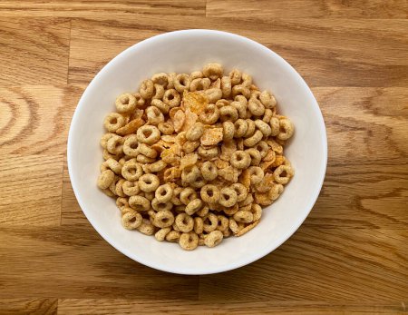 Photo for Bowl of breakfast cereal on wooden kitchen table, top view - Royalty Free Image