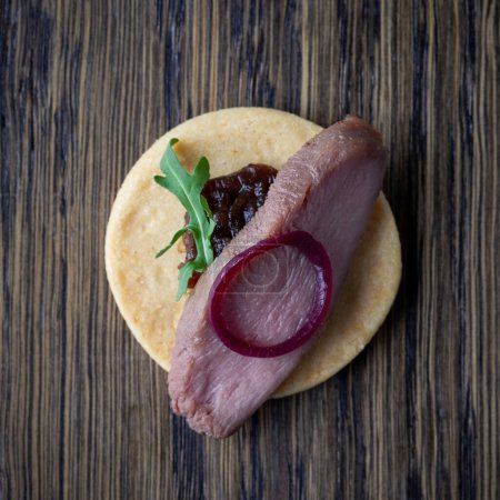 Téléchargez les photos : Cookie avec filet de canard rôti et confiture d'oignon rouge sur table en bois, vue sur le dessus - en image libre de droit