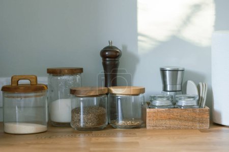 Foto de Varios frascos y recipientes en la mesa de la cocina y fondo de pared - Imagen libre de derechos
