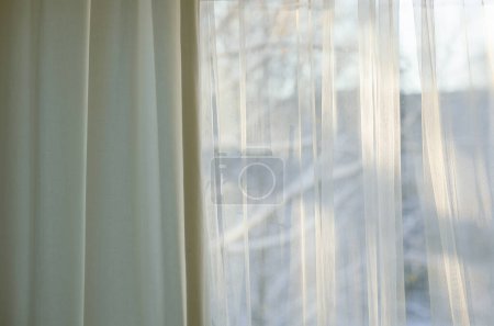 Foto de Cortinas cuelgan en frente de la ventana de invierno soleado - Imagen libre de derechos