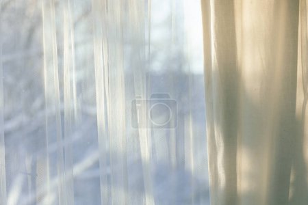 Foto de Cortinas cuelgan en frente de la ventana de invierno soleado - Imagen libre de derechos