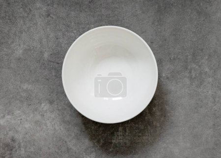 Foto de Cuenco blanco vacío en la mesa de cocina gris, vista superior - Imagen libre de derechos