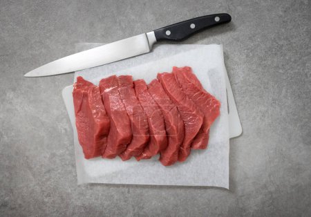 Photo for Fresh raw sliced beef meat on cutting board, top view - Royalty Free Image