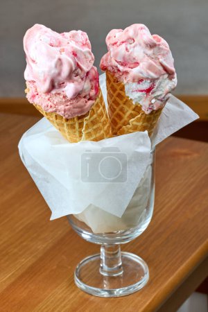 Téléchargez les photos : Pink ice cream in cones on restaurant table - en image libre de droit