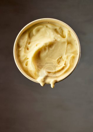 Foto de Levitating paper cup of melting vanilla ice cream - Imagen libre de derechos