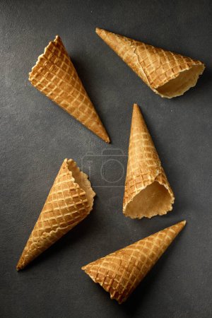 Photo for Waffle ice cream cones on dark grey background, top view - Royalty Free Image