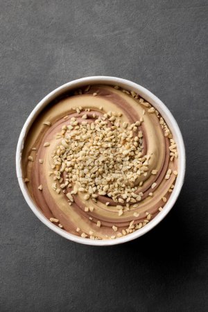 Téléchargez les photos : Open caramel and chocolate ice cream package on dark grey background, top view - en image libre de droit