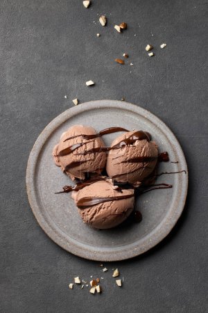 Photo for Chocolate ice cream portion decorated with melted chocolate and almonds on grey table, top view - Royalty Free Image