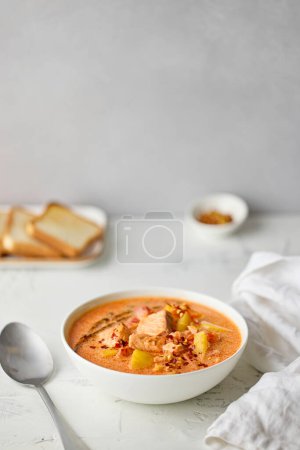 Foto de Bowl of salmon soup on white kitchen table, still life - Imagen libre de derechos