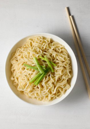 Photo for Bowl of boiled noodles and chopsticks on white table, top view - Royalty Free Image