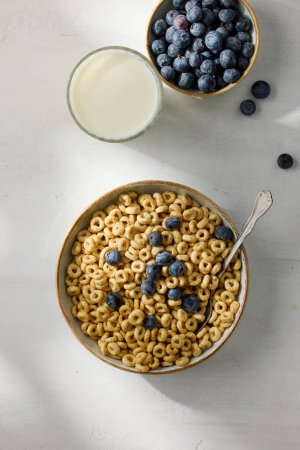 Foto de Tazón de desayuno anillos de miel de cereales y leche en la mesa de la cocina blanca, vista superior - Imagen libre de derechos
