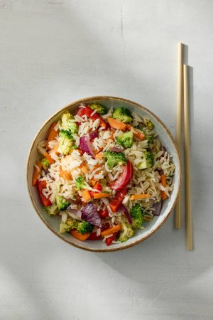 Téléchargez les photos : Bowl of fried rice with vegetables on white kitchen table, top view - en image libre de droit