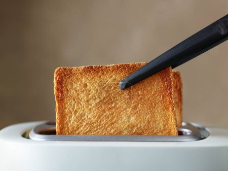 Photo for Freshly toasted bread slices in a toaster - Royalty Free Image