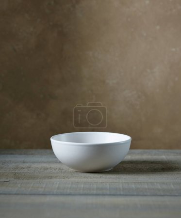 Photo for Empty white bowl on kitchen table, wall background - Royalty Free Image