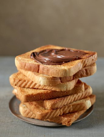 Foto de Pila de rebanadas de pan tostado con crema de chocolate en la mesa de la cocina - Imagen libre de derechos