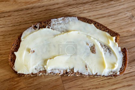 Téléchargez les photos : Pain de seigle avec beurre sur table de cuisine en bois, vue sur le dessus - en image libre de droit