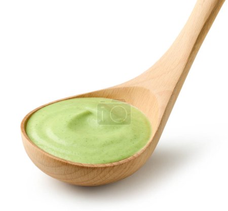Téléchargez les photos : Soupe verte à la crème de légumes en louche de bois isolée sur fond blanc - en image libre de droit