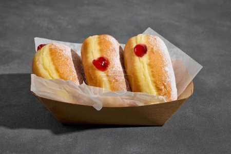 Photo for Freshly baked jelly donuts on dark grey background - Royalty Free Image
