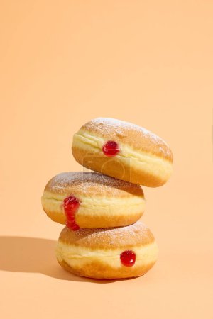 Photo for Stack of freshly baked jelly donuts on orange background - Royalty Free Image