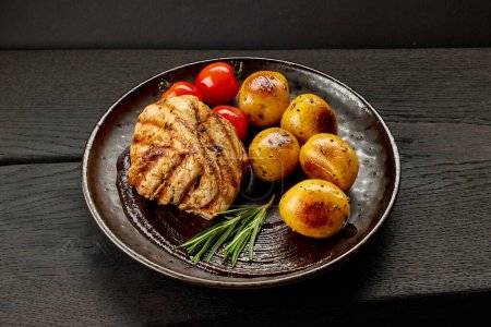Téléchargez les photos : Steak de filet de porc fraîchement grillé sur table en bois noir - en image libre de droit