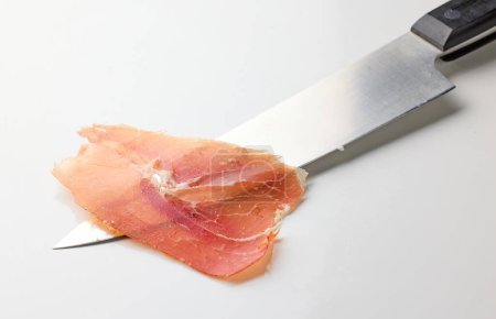 Photo for Sliced spanish iberico ham and knife on white background - Royalty Free Image