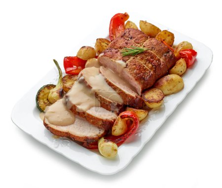 Foto de Primer plano de cerdo asado en rodajas con verduras y salsa en plato blanco - Imagen libre de derechos