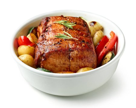 Foto de Bowl of whole roast pork and vegetables isolated on white background - Imagen libre de derechos