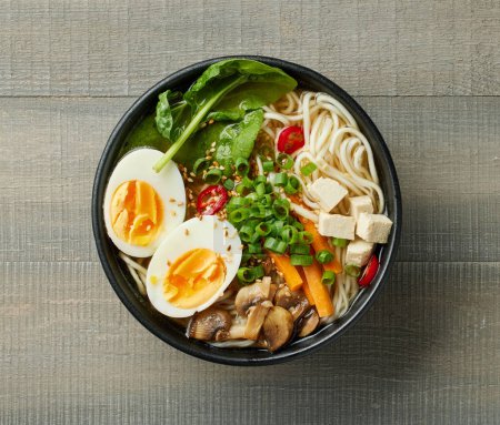 Téléchargez les photos : Bol de soupe de nouilles ramen asiatique végétarienne sur fond en bois, vue de dessus - en image libre de droit