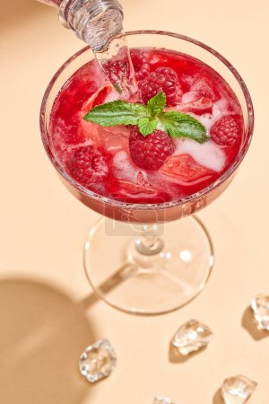 Téléchargez les photos : Cocktail d'été tendance Rosito framboise verser dans le verre - en image libre de droit