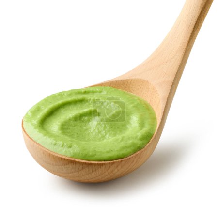 Foto de Sopa de crema vegetal verde en cucharón de madera aislado sobre fondo blanco - Imagen libre de derechos
