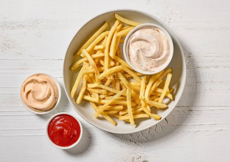 Photo for French fries with various dip sauces on white wooden table, top view - Royalty Free Image