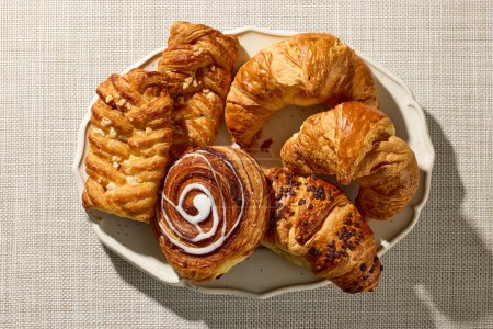 Photo for Plate of assorted pastries on kitchen table, top view - Royalty Free Image