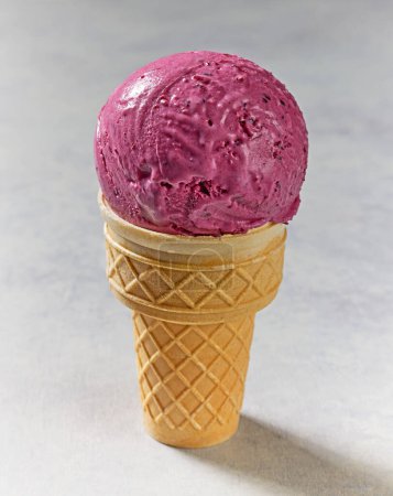 Foto de Primer plano de helado de grosella negra en un cono de gofre - Imagen libre de derechos