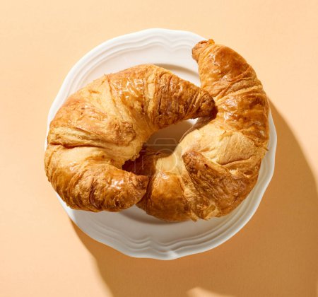 Photo for Freshly baked croissants on white plate, top view - Royalty Free Image