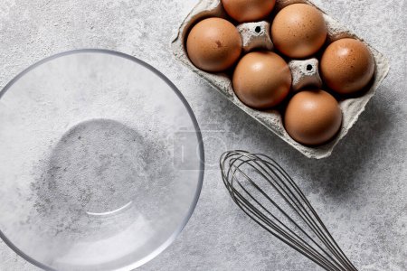 Foto de Tazón y huevos sobre fondo de mesa de cocina pintada gris claro, vista superior - Imagen libre de derechos