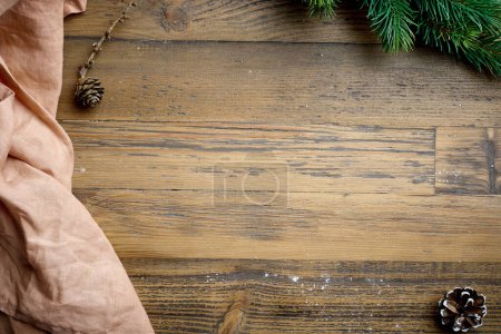 Photo for Wooden kitchen table with linen towel and fir tree branch, top view. Christmas baking background - Royalty Free Image