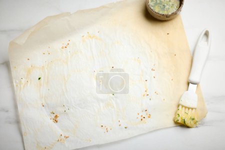 Téléchargez les photos : Vide de papier de cuisson d'occasion après la cuisson sur la table de cuisine légère, vue de dessus - en image libre de droit