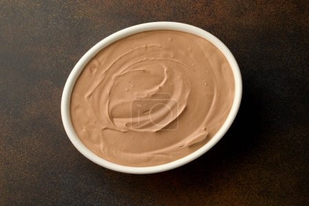 Photo for Bowl of homemade chocolate ice cream on brown background, top view - Royalty Free Image
