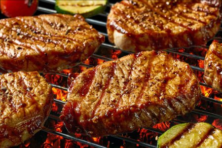 Photo for Freshly grilled juicy steaks and vegetables on burning charcoal grill - Royalty Free Image