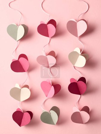 Téléchargez les photos : Coeurs décoratifs en papier coloré sur fond rose, vue de dessus - en image libre de droit
