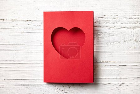 Photo for Red paper greeting card with heart shape on white wooden background, top view - Royalty Free Image