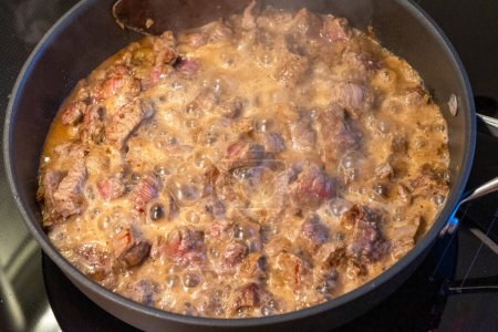 Photo for The meat is stewed in a pan, process of making beef stroganoff - Royalty Free Image