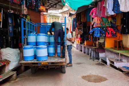Téléchargez les photos : Pushkar, India - November 7, 2019: Men unloading milk from truck in street of Pushkar, Rajasthan, India - en image libre de droit