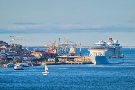 Téléchargez les photos : Vue de Lisbonne sur le Tage depuis Almada avec yachts bateaux de tourisme et paquebots de croisière amarrés au terminal de croisière au coucher du soleil. Lisbonne, Portugal - en image libre de droit