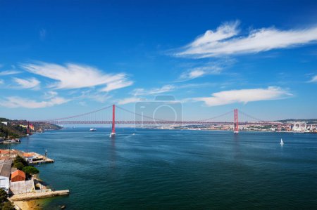 Téléchargez les photos : Vue du pont 25 de Abril célèbre monument touristique de Lisbonne reliant Lisboa à Almada sur la péninsule de Setubal sur le Tage avec des bateaux yachts et bateaux. Lisbonne, Portugal - en image libre de droit