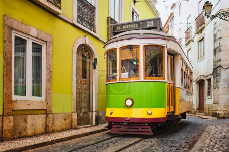 Foto de Famoso tranvía amarillo vintage 28 en las estrechas calles del distrito de Alfama en Lisboa, Portugal - símbolo de Lisboa, famoso destino turístico y atracción turística - Imagen libre de derechos